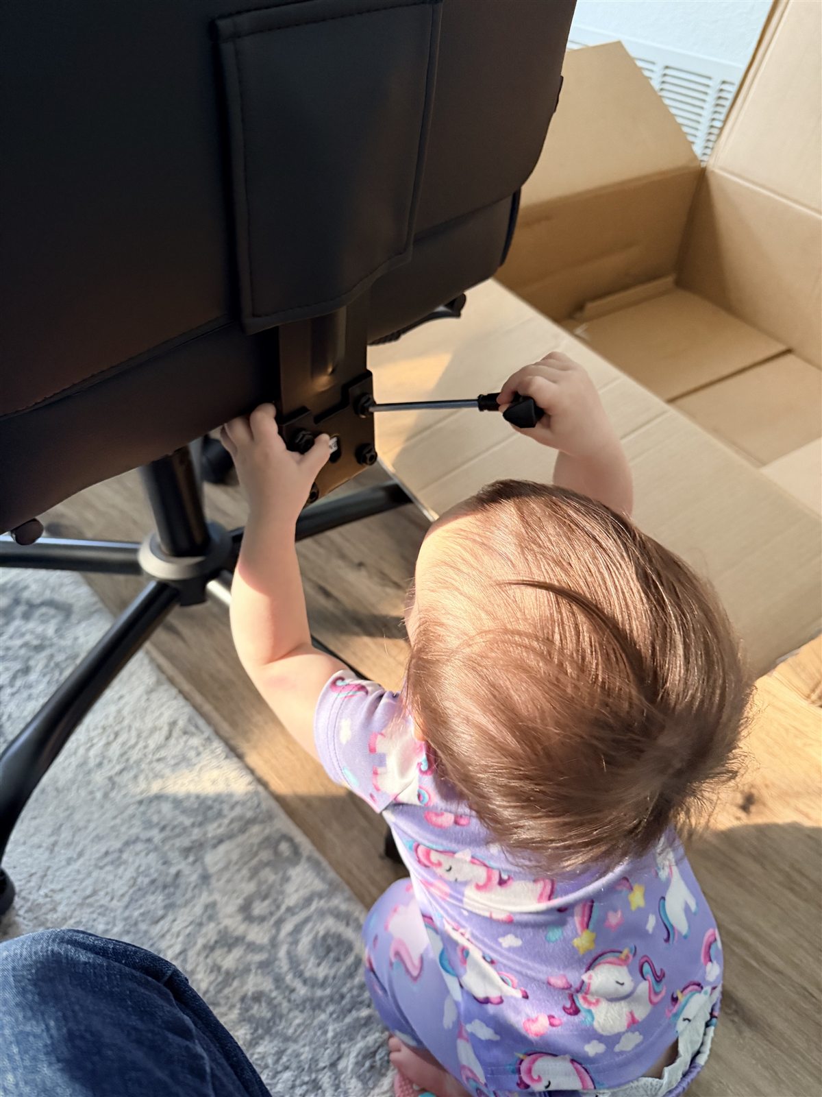 A young child helping with a screwdriver